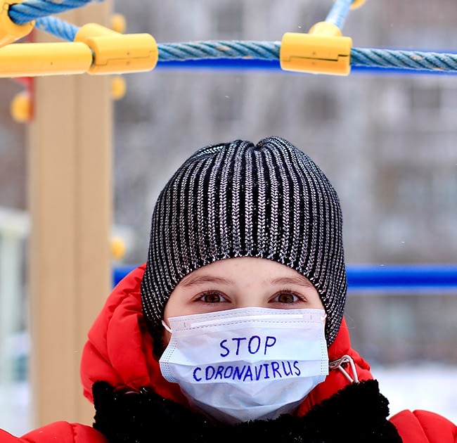 WOman wearing a coronavirus mask on a playground