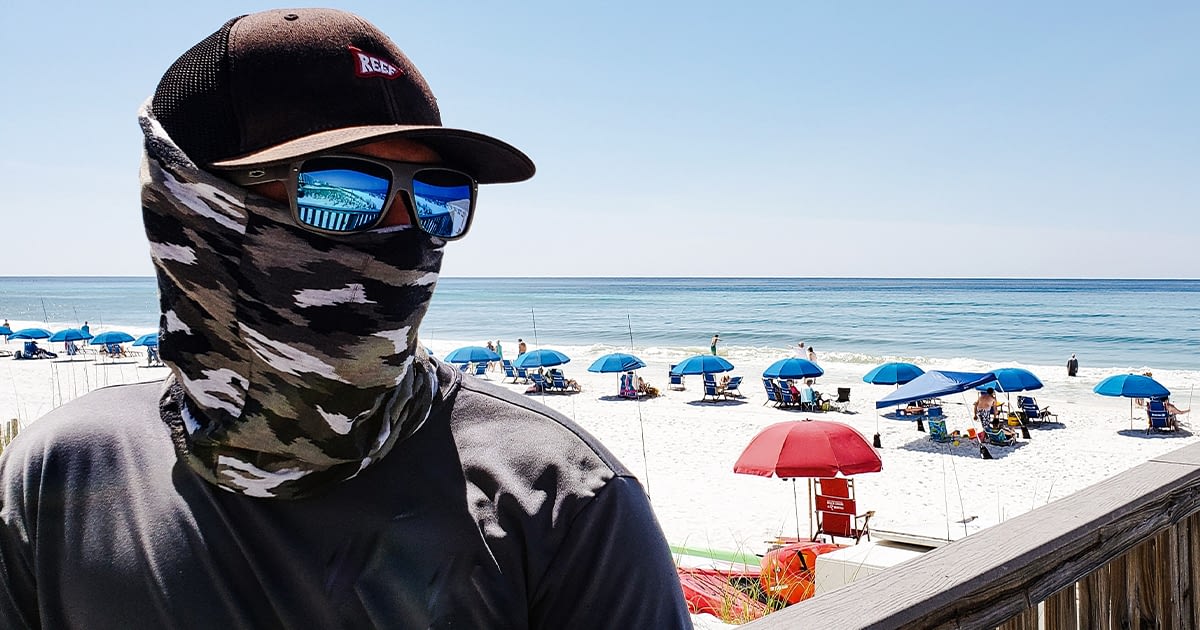 Man wearing a bandana face cloth at the beach in california during Covid-19
