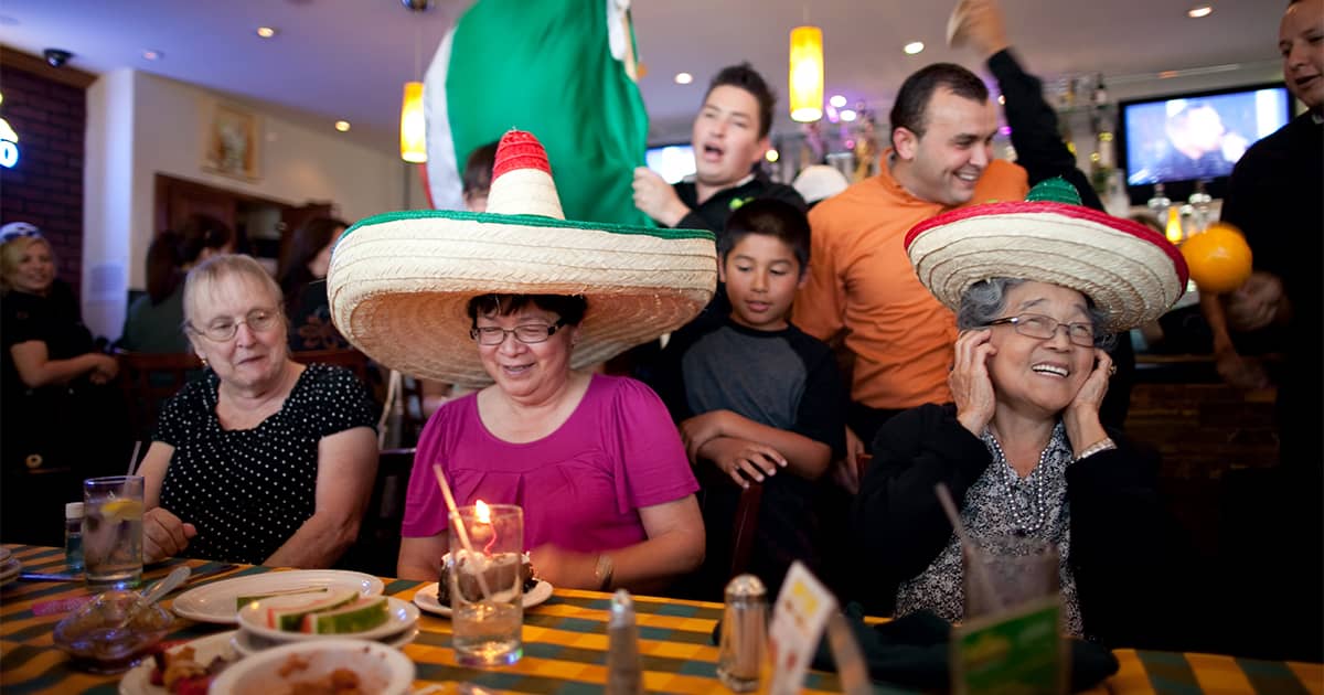 Family eating Mexican food in sombreros.