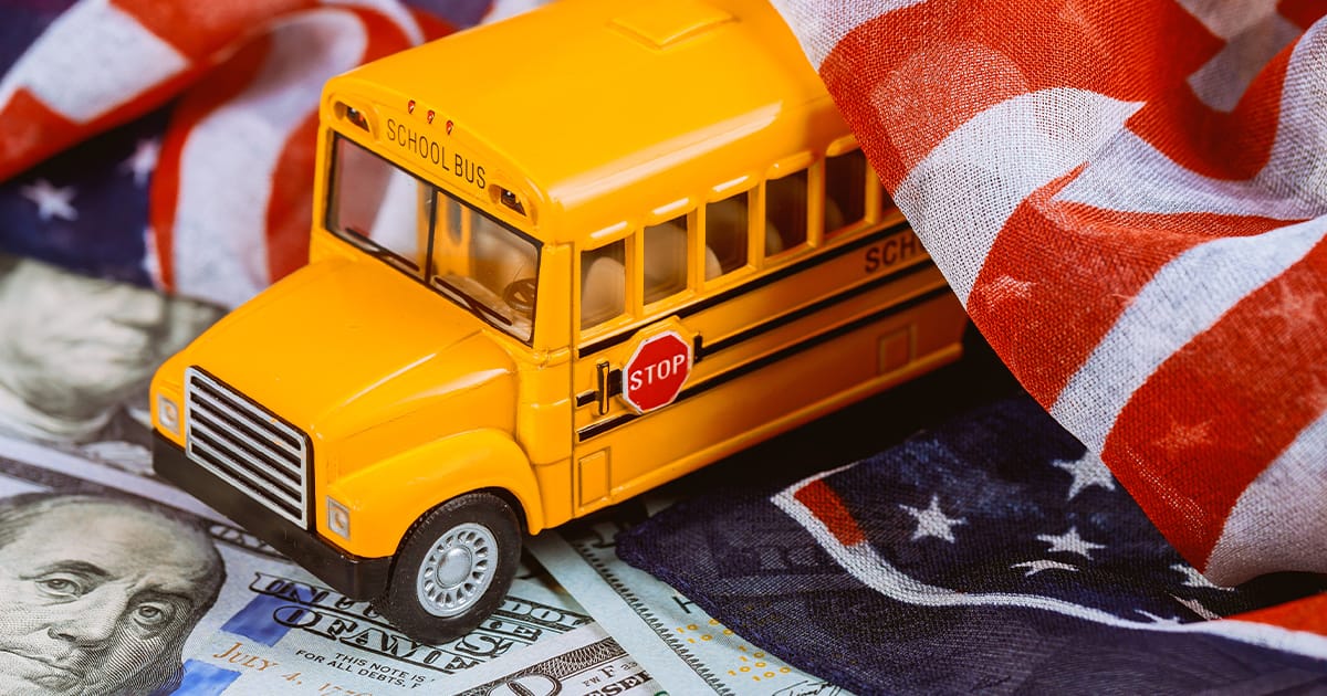 american money with a school bus and a flag