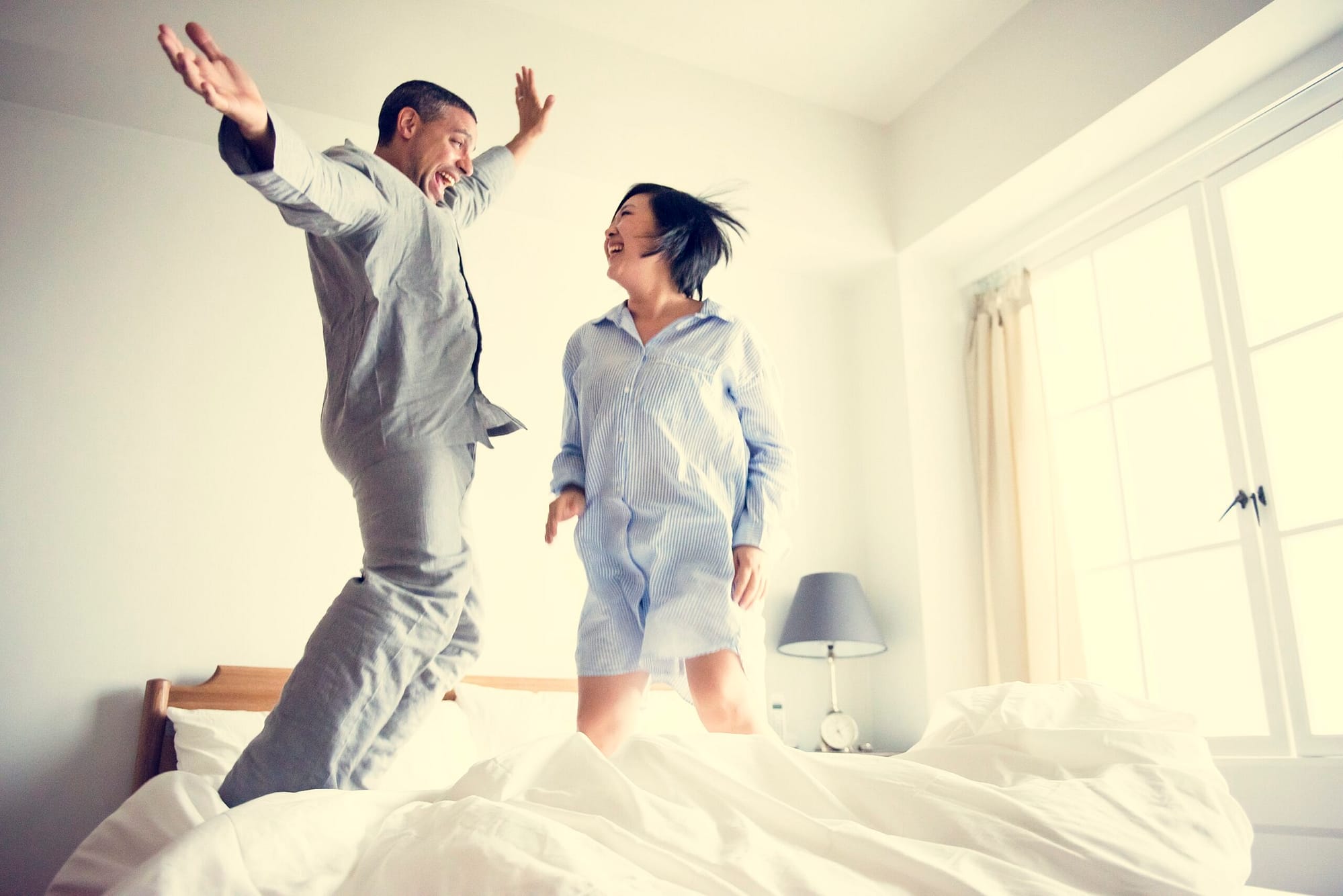 A couple jumps for joy after purchasing a new matress at Discount Mattress Lady.